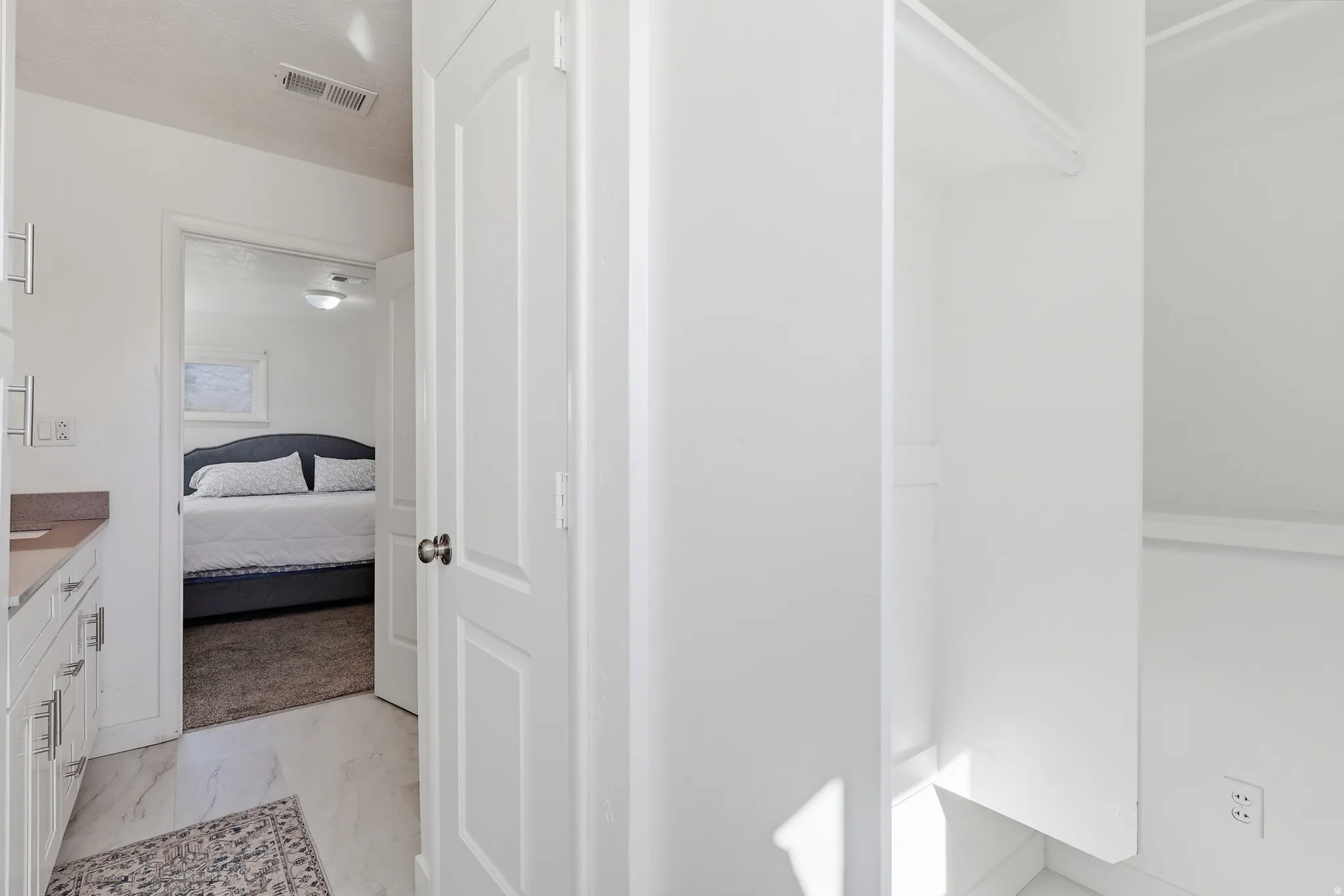 Ensuite bathroom with vanity and light marble finish flooring