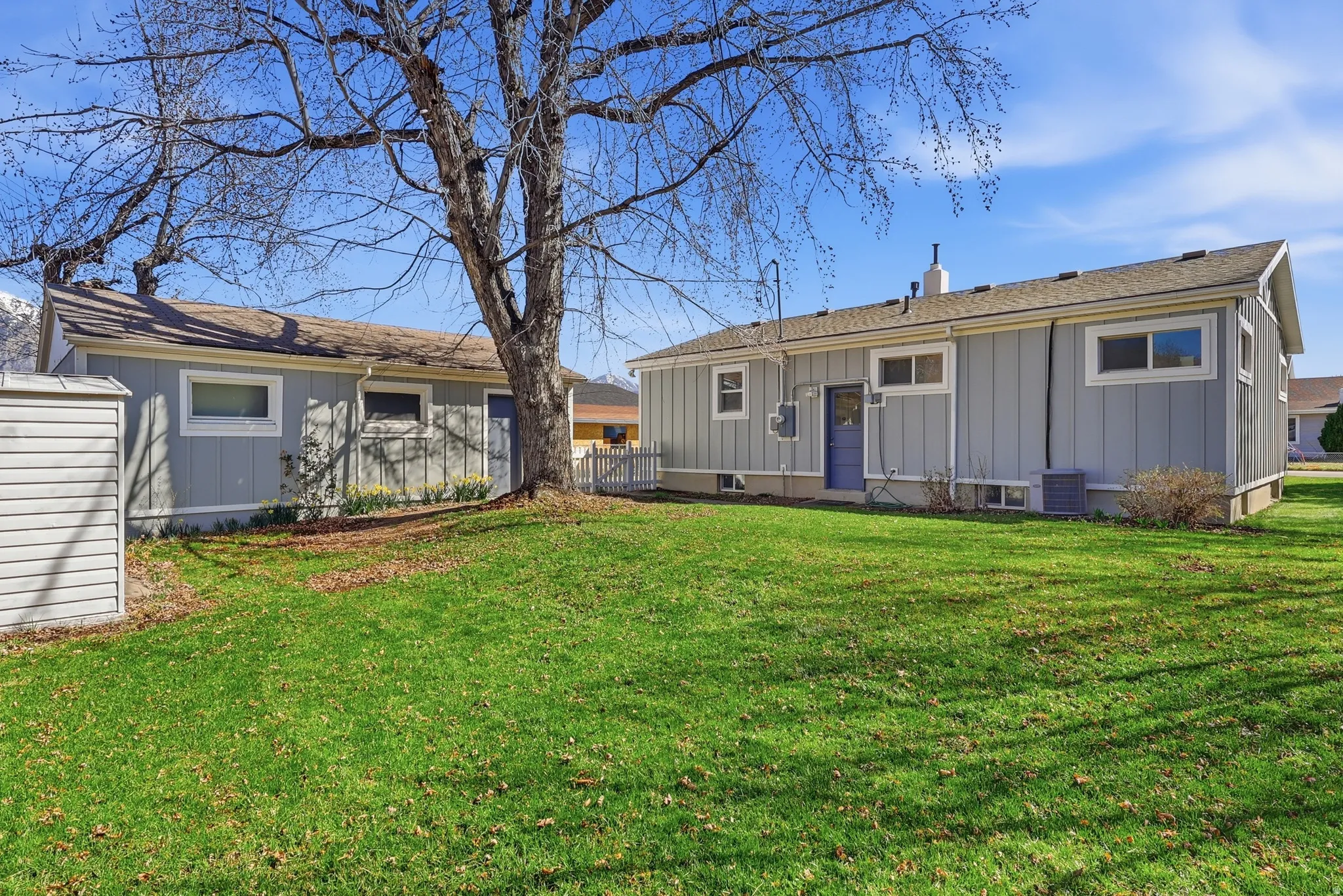 Rear view of house featuring board and batten siding and a lawn
