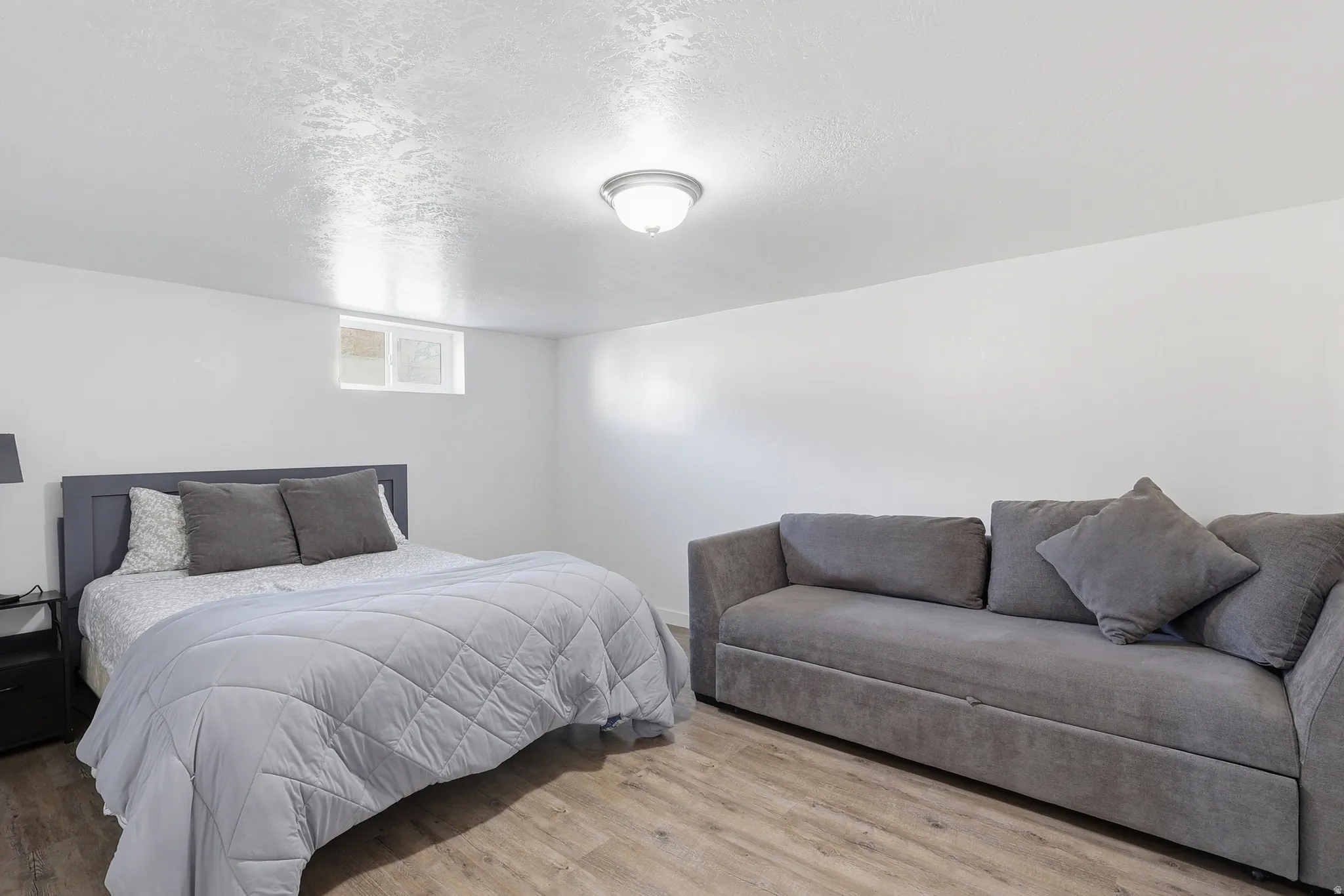 Bedroom with light wood-style flooring and a textured ceiling