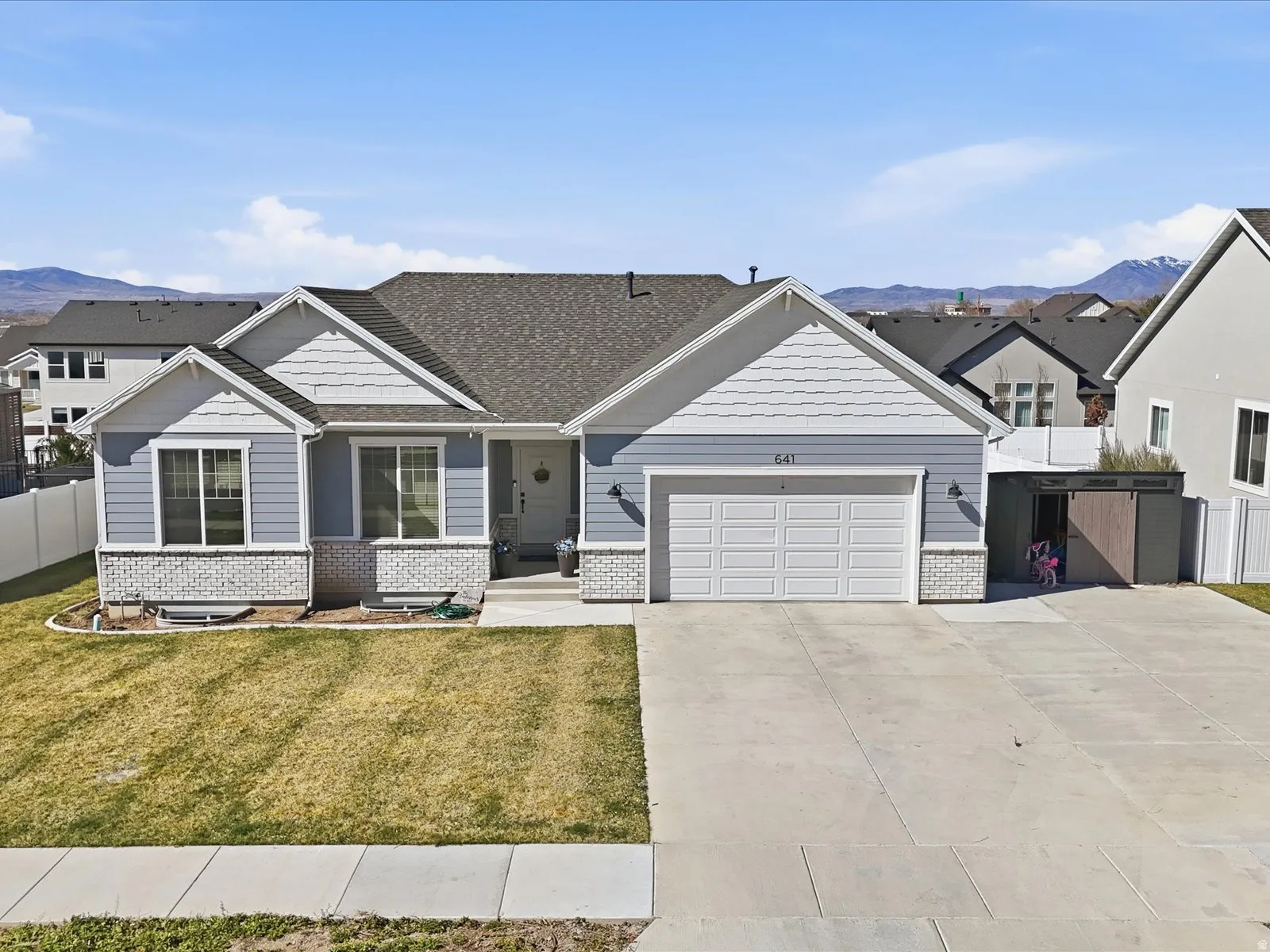 Craftsman-style house featuring a mountain view, brick siding, concrete driveway, an attached garage, and a residential view