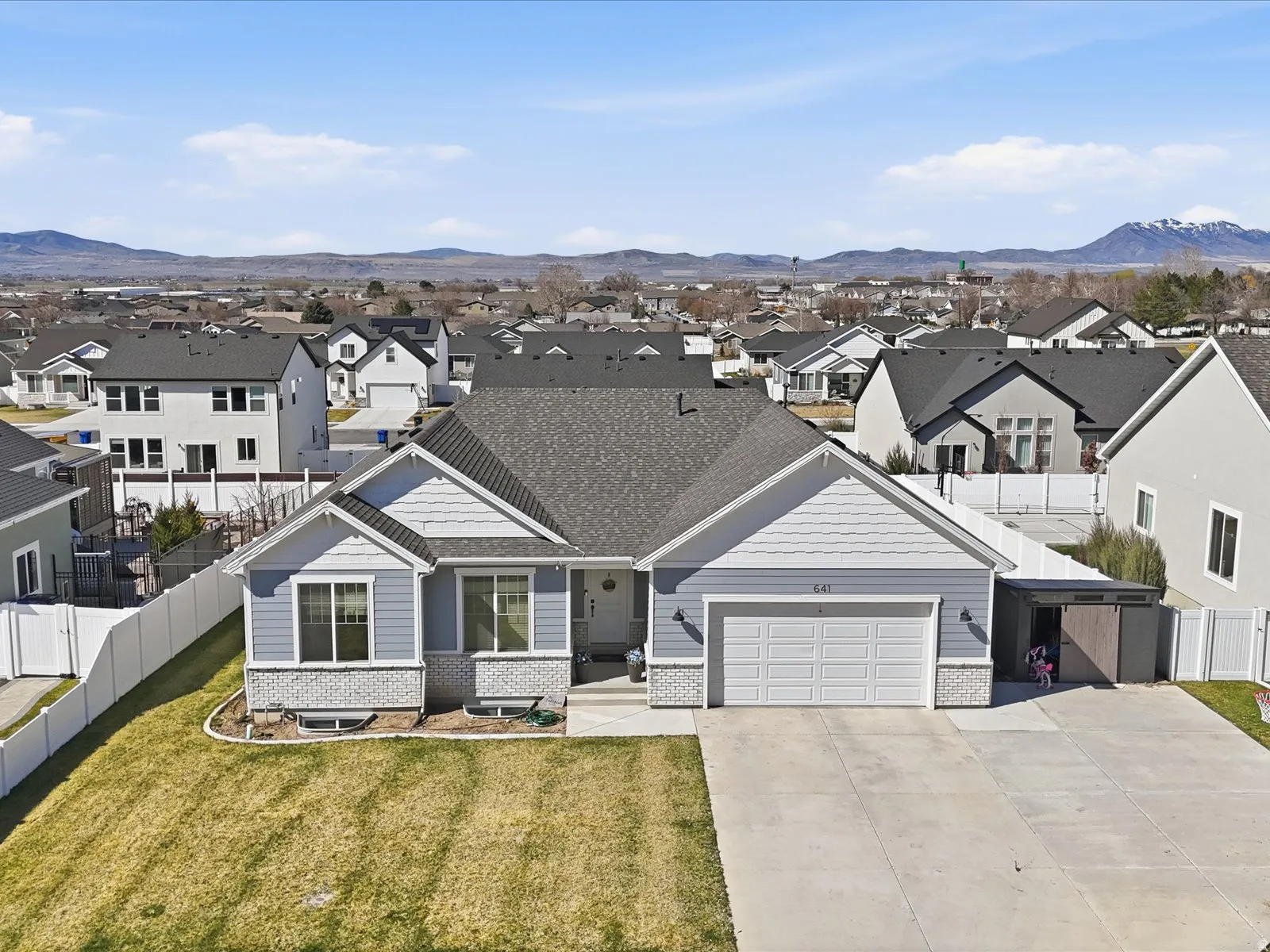 View of front facade featuring a residential view, an attached garage, concrete driveway, and brick siding