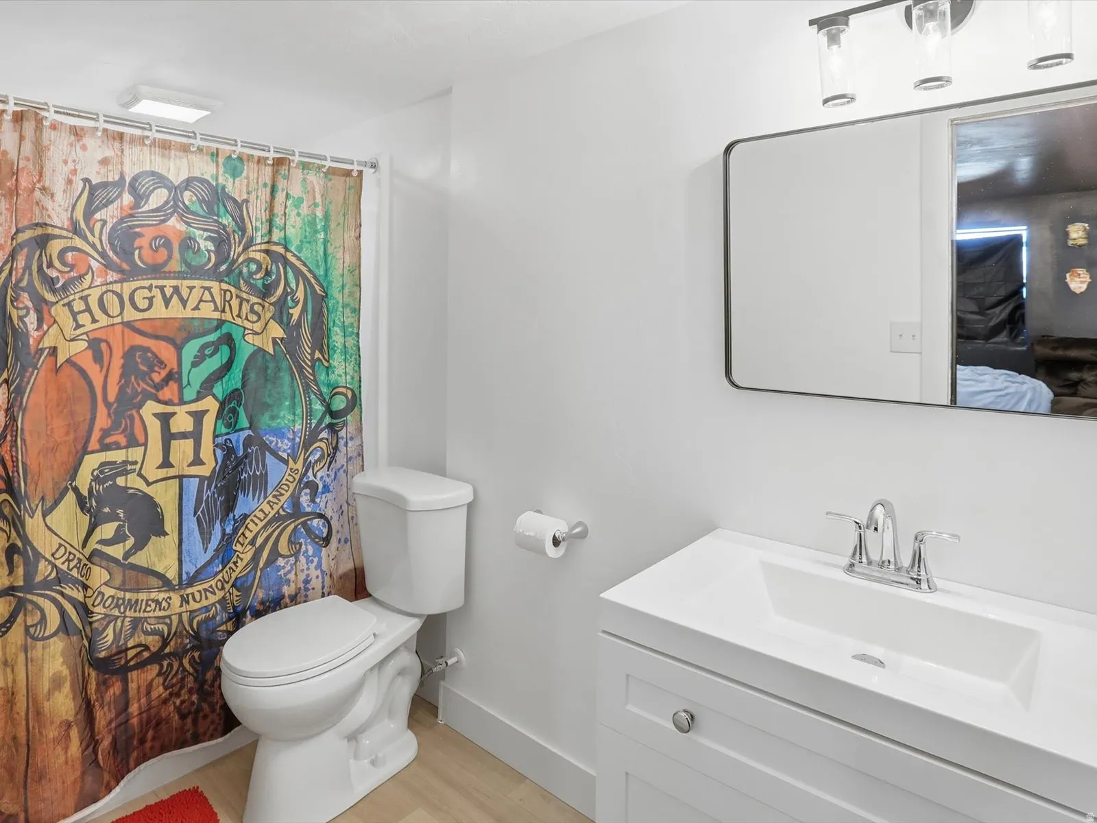 Bathroom featuring vanity, curtained shower, and light wood-type flooring