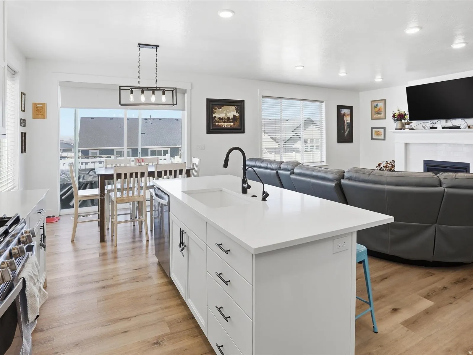 Kitchen with open floor plan, a breakfast bar area, white cabinetry, and light wood finished floors