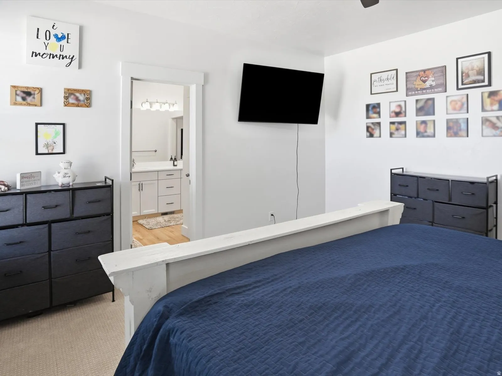Bedroom featuring light carpet, connected bathroom, and ceiling fan