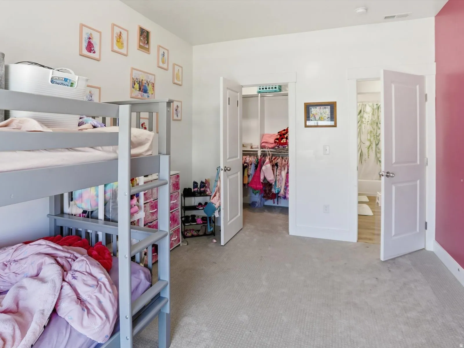 Bedroom featuring a spacious closet and light colored carpet