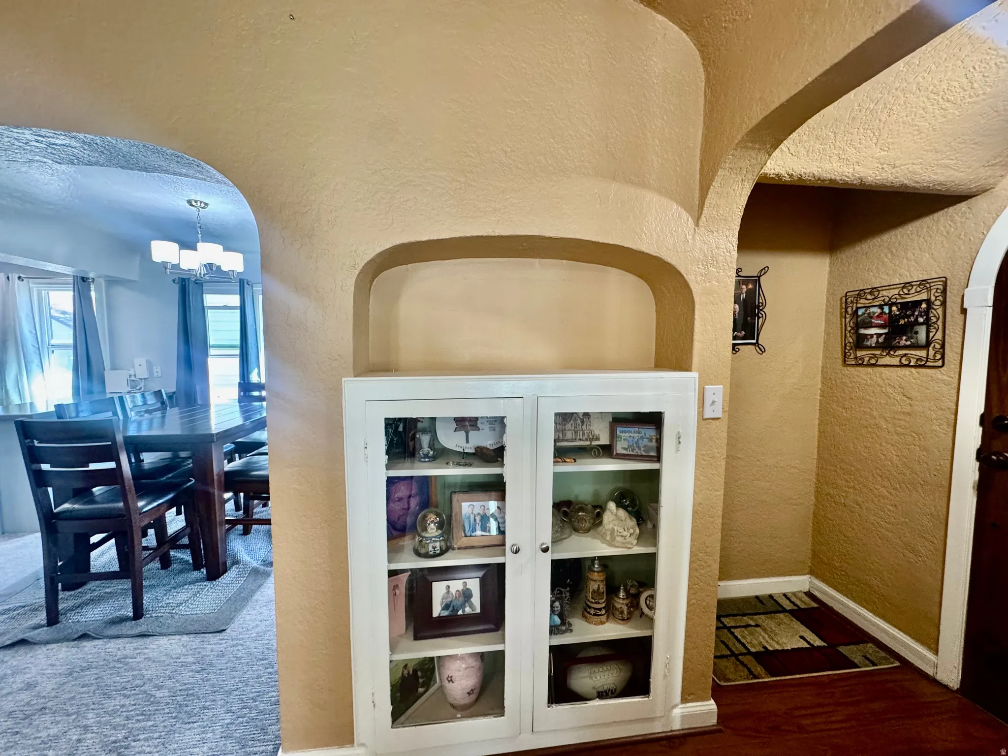 Detailed view of a textured wall, arched walkways, and suspended lighting