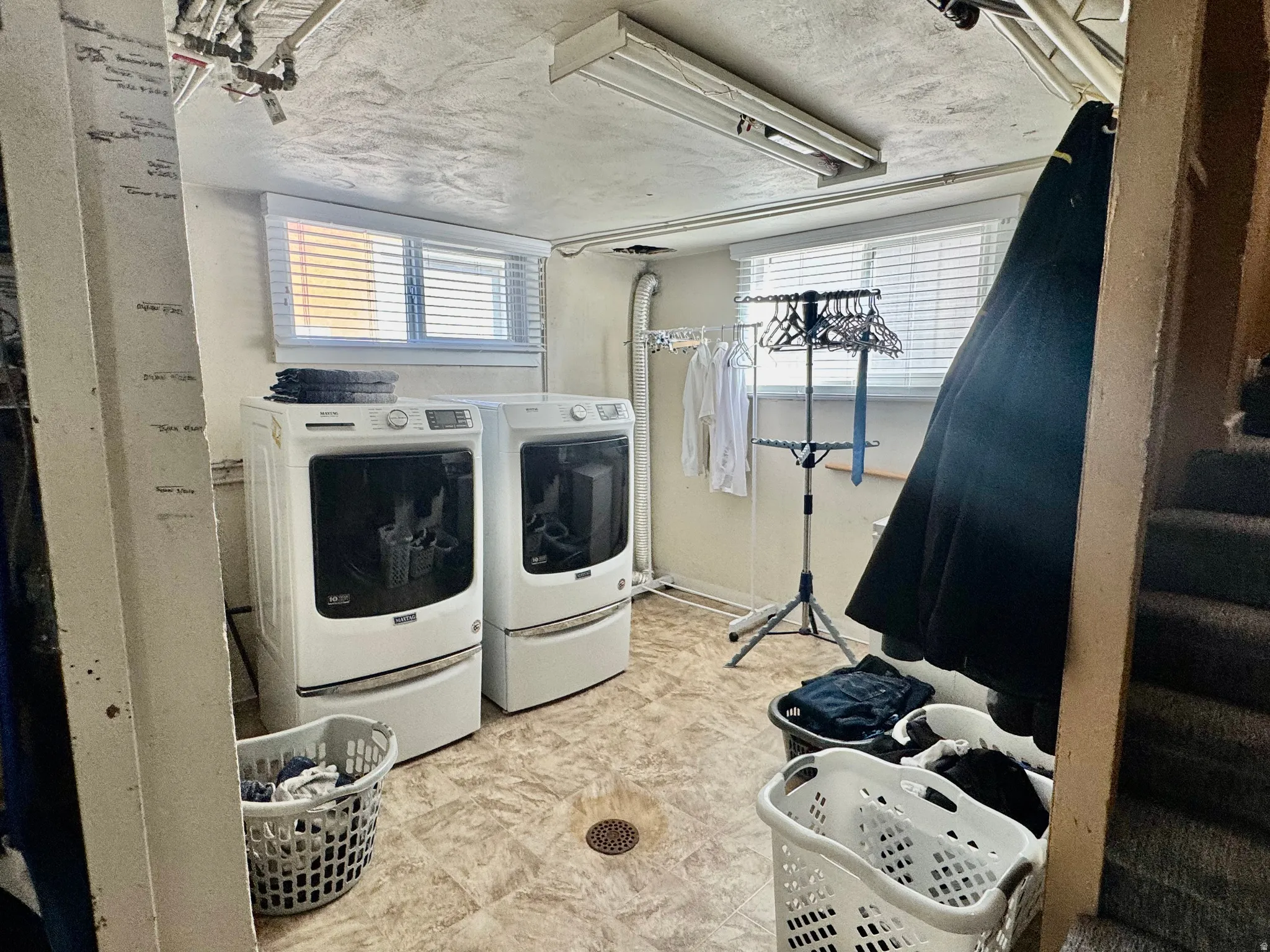 Laundry area with separate washer and dryer and baseboards
