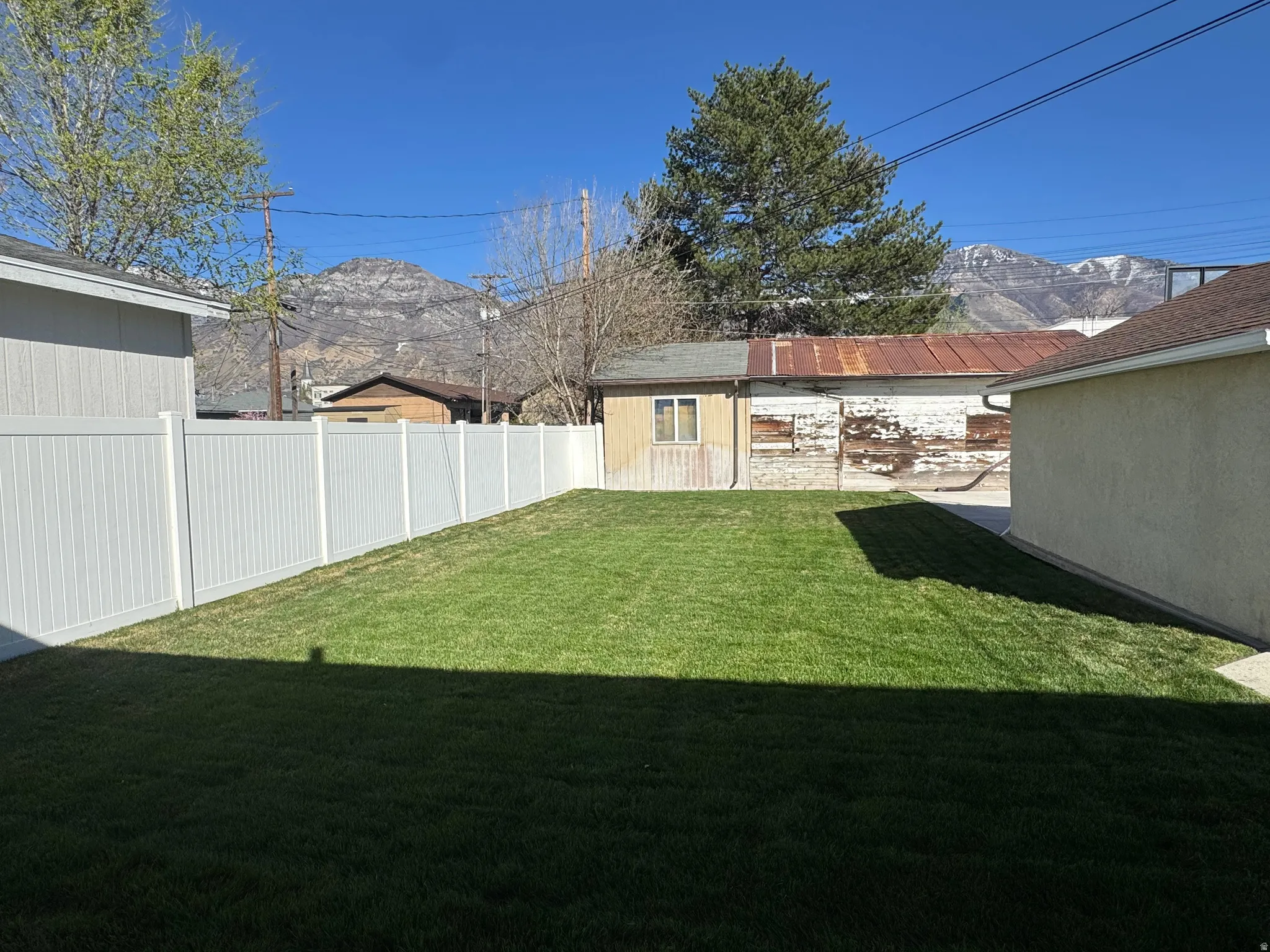 Fenced backyard featuring a mountain view and an outdoor structure