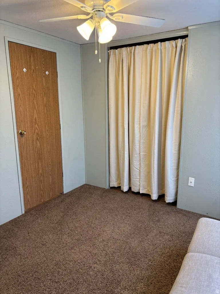 Carpeted bedroom featuring ceiling fan