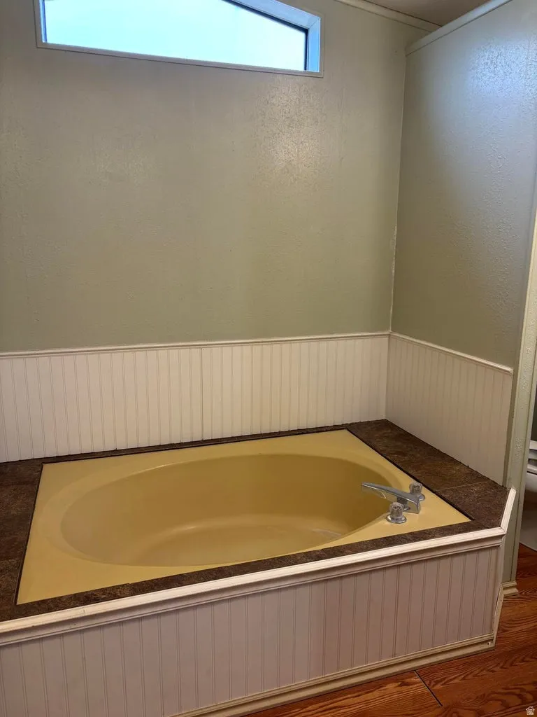 Full bath with a wainscoted wall and a garden tub