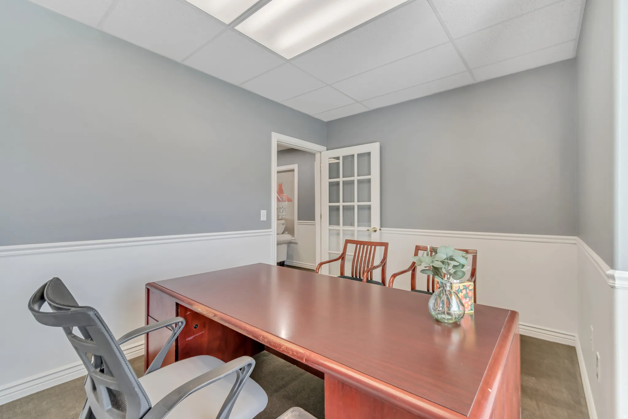 Office with a drop ceiling and baseboards