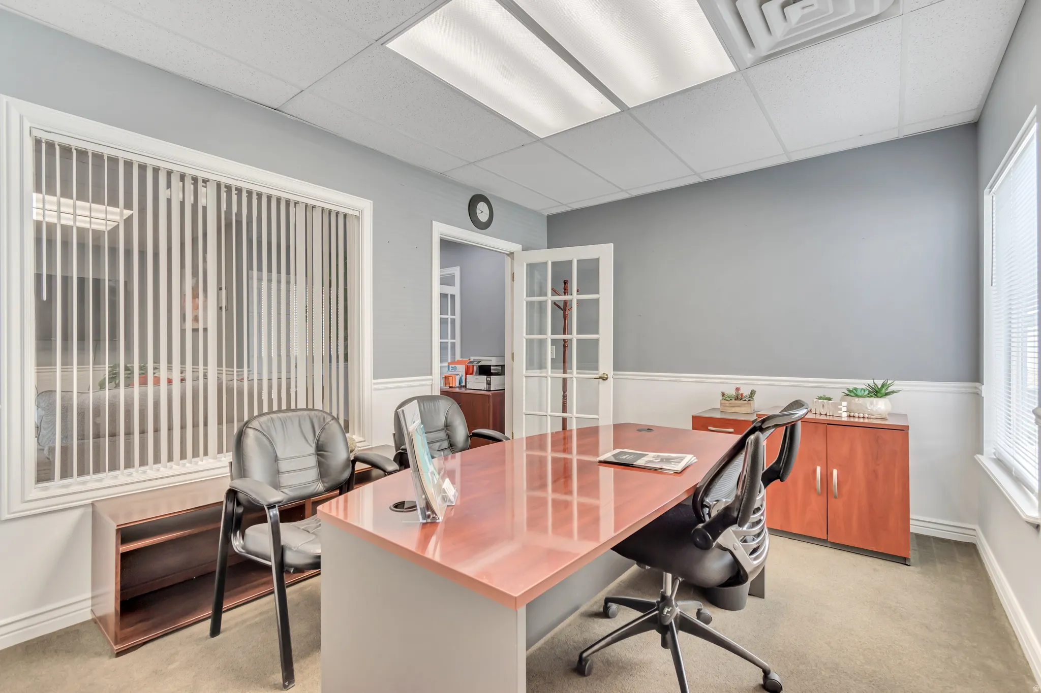 Office area featuring a paneled ceiling, light colored carpet, and french doors
