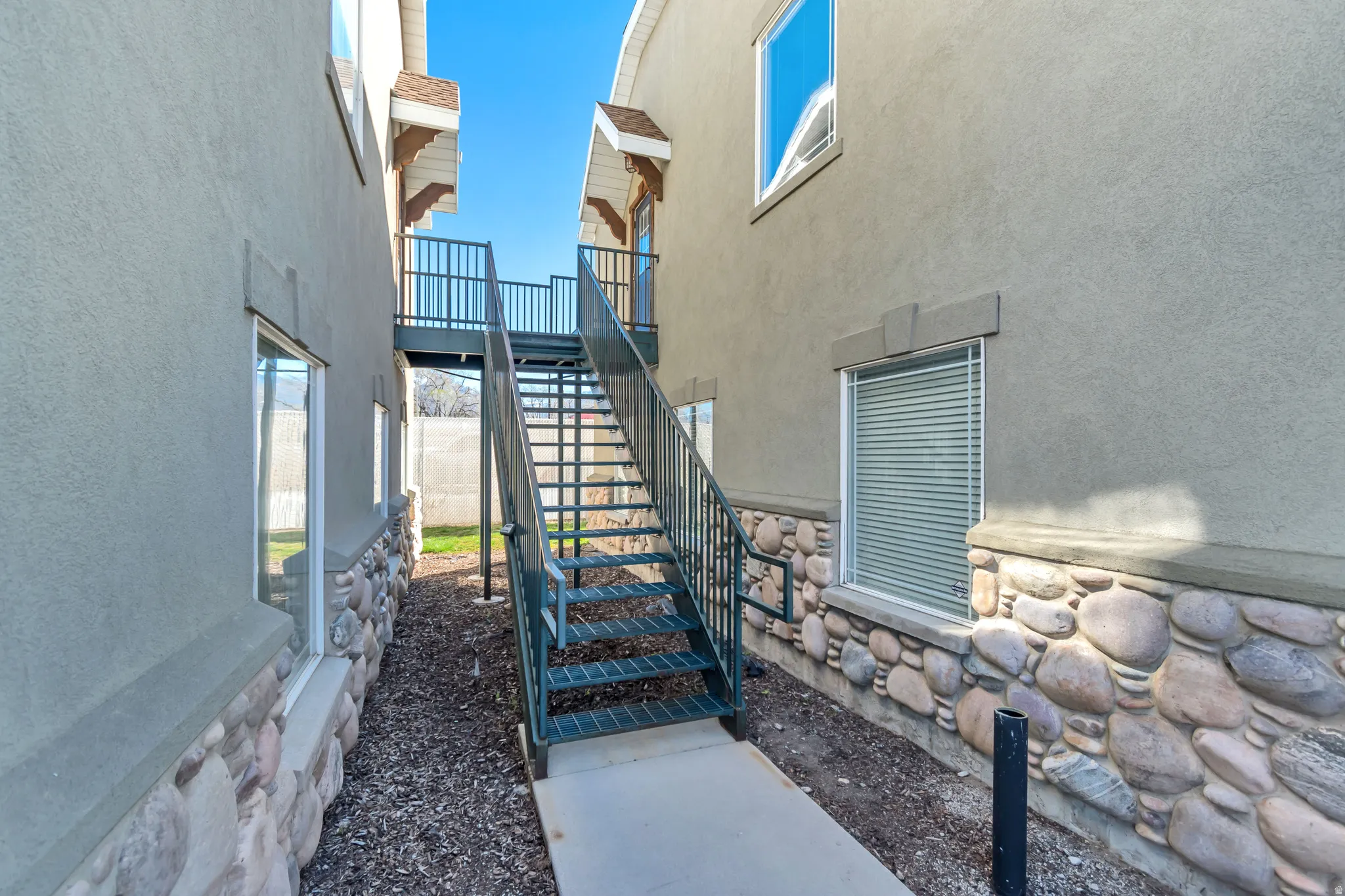 View of side of property with stucco siding and stairway