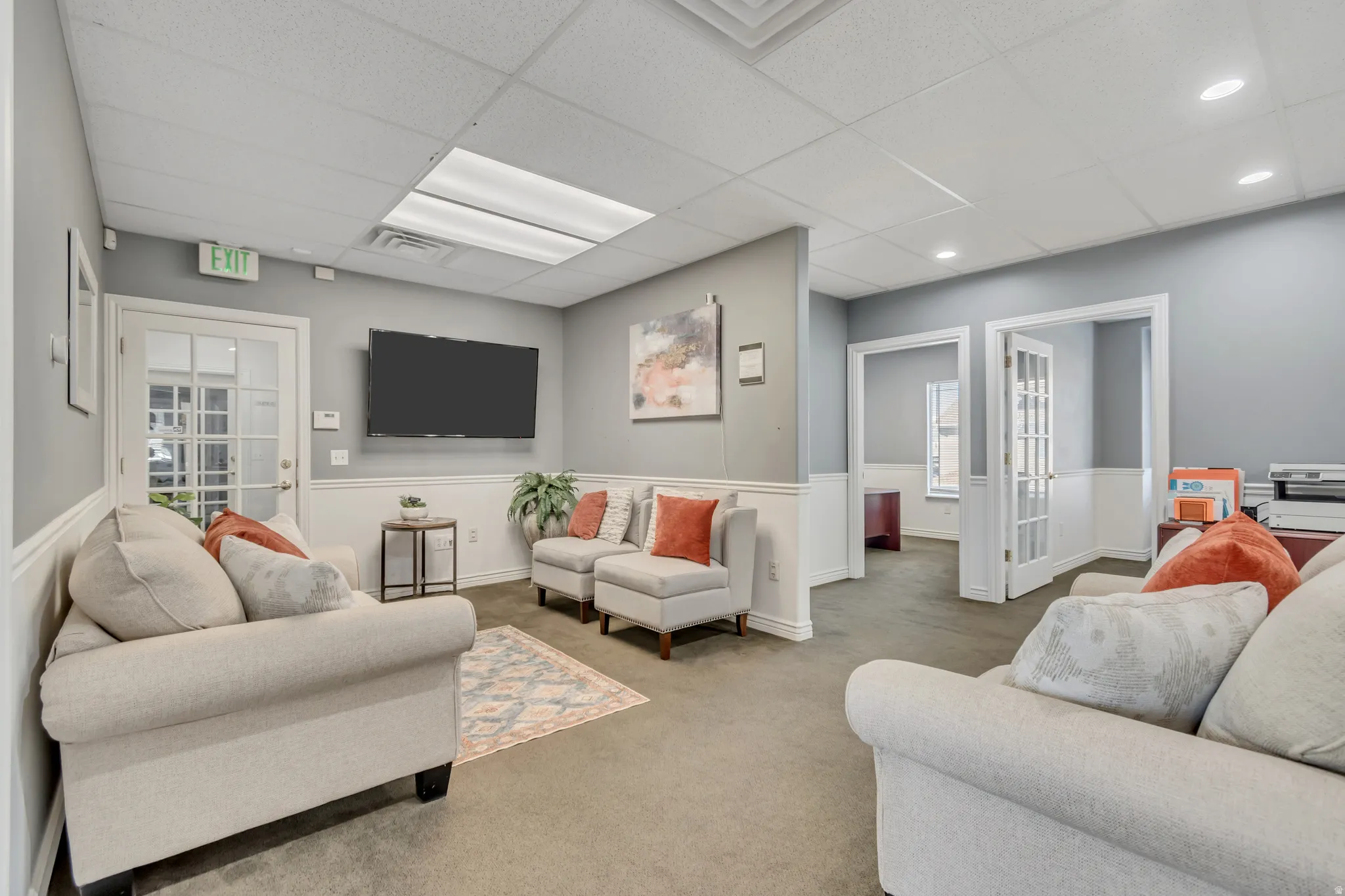 Carpeted living room with a drop ceiling