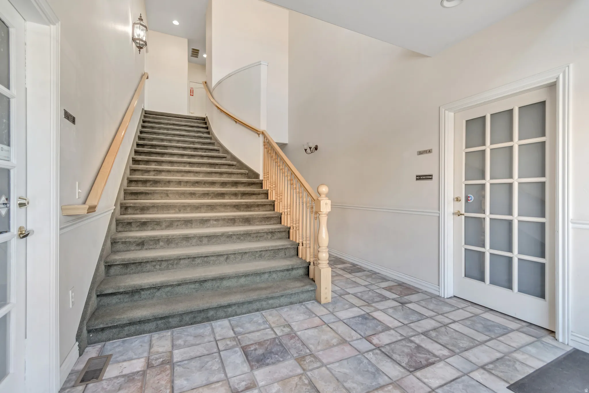 Staircase with stone tile flooring and recessed lighting