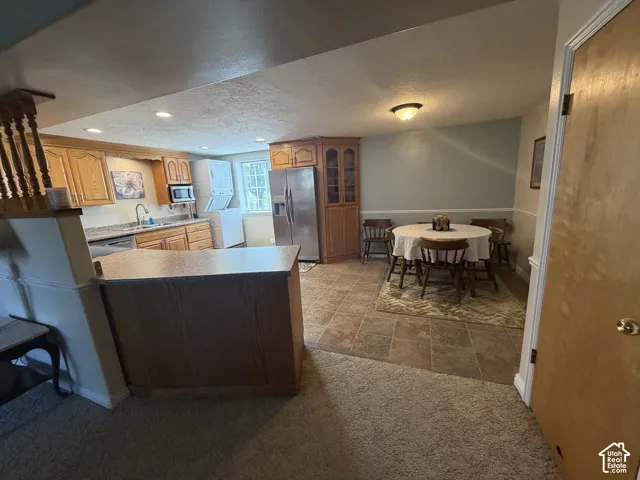 Kitchen and dining area featuring wood cabinetry, stainless steel appliances, and tiled flooring