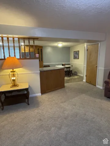 Carpeted flooring extending into a dining area with wood-finish cabinetry and a built-in countertop