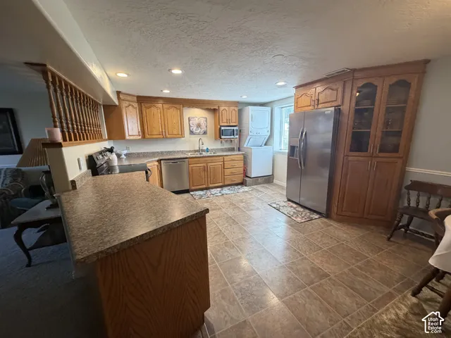 Kitchen featuring wood cabinetry, stainless steel appliances, tile flooring, and recessed lighting