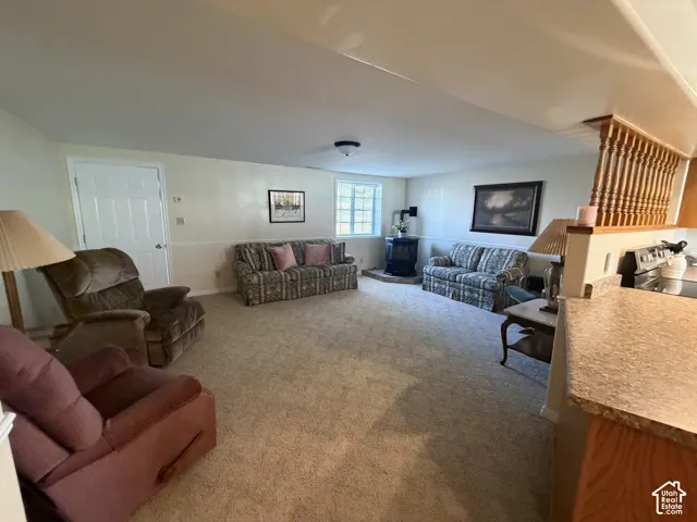 Carpeted living area featuring a built-in wood-burning stove and a window with natural light