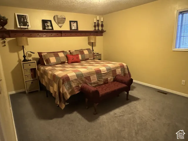 Bedroom featuring a textured ceiling and carpet floors