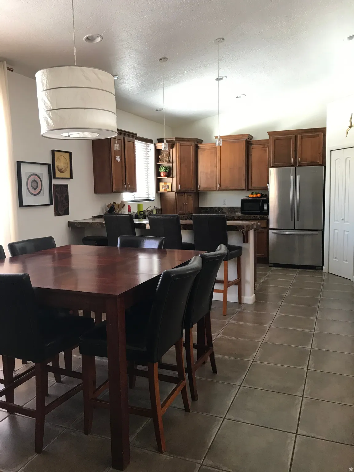 Dining room featuring dark tile patterned flooring and a textured ceiling