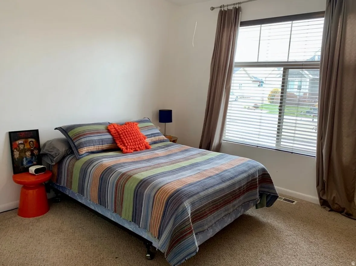 Bedroom with baseboards and light carpet