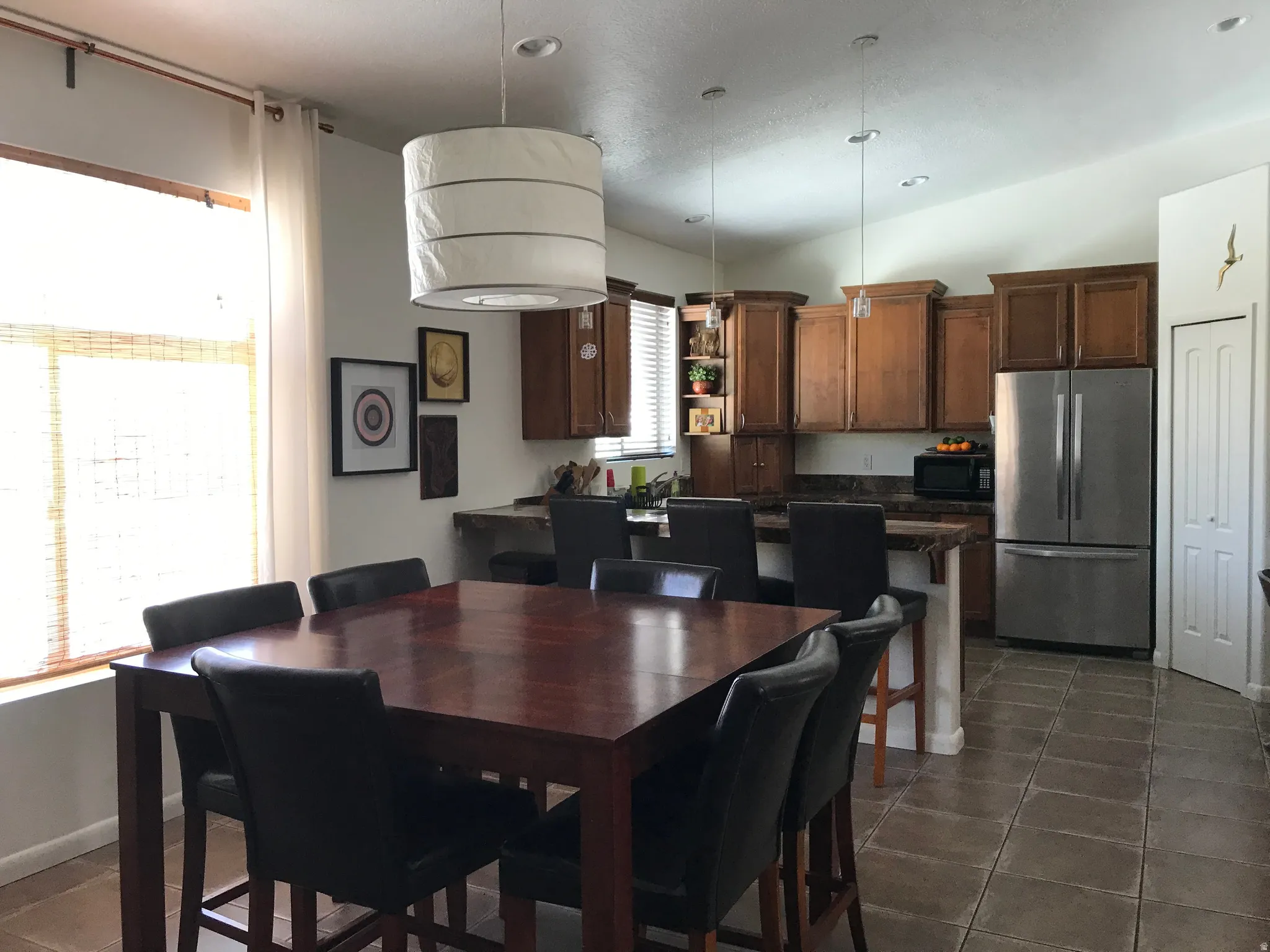 Dining room featuring vaulted ceiling and dark tile patterned flooring