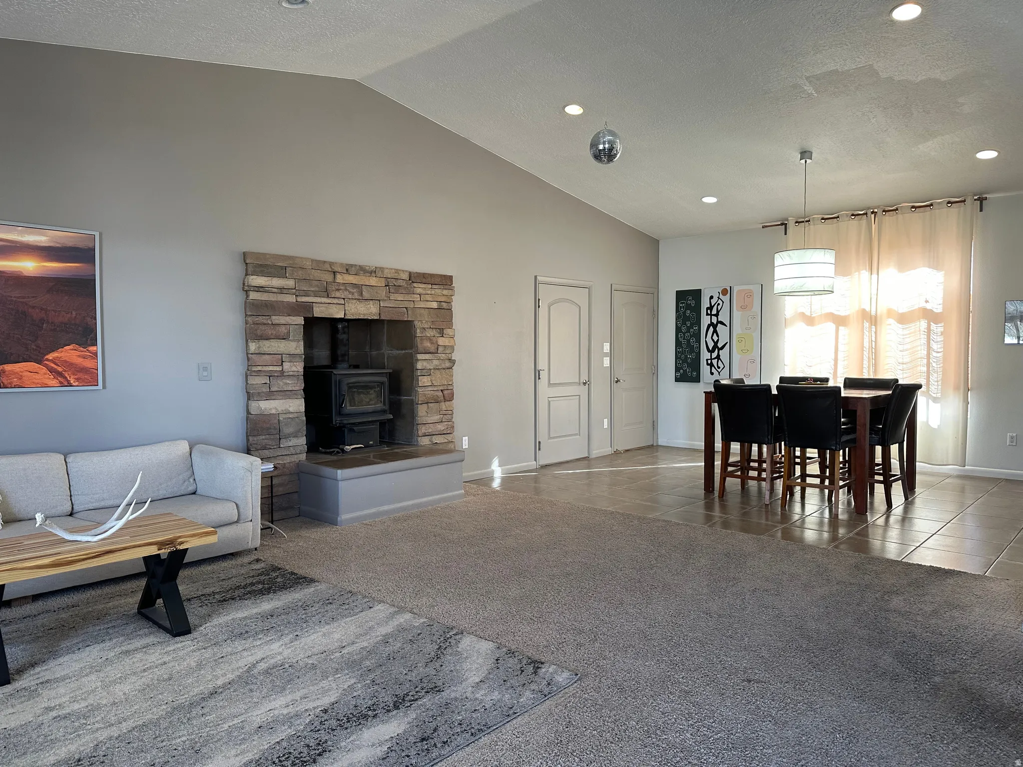Living area featuring carpet, tile patterned flooring, recessed lighting, and a wood stove