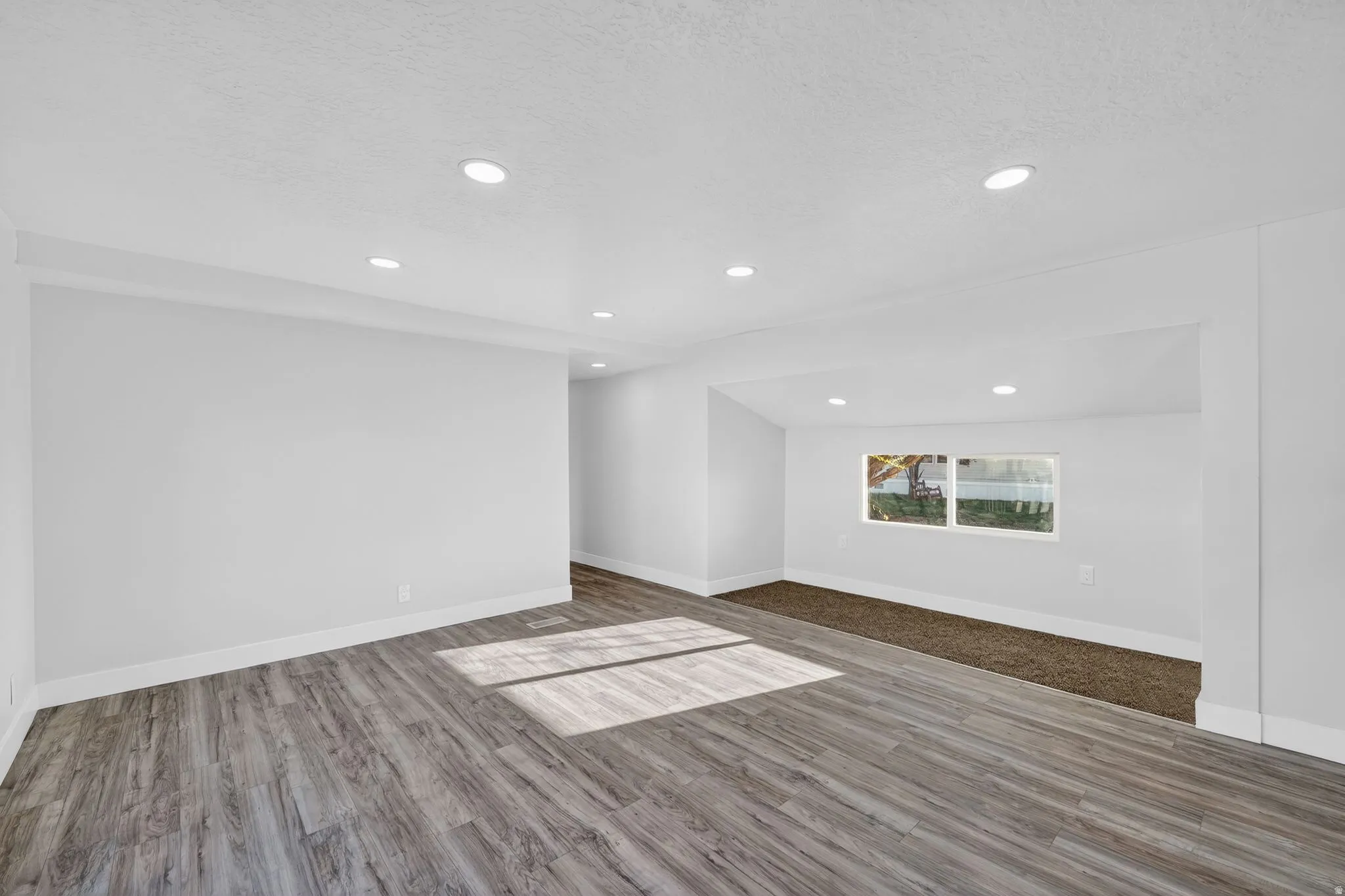 Spare room with light wood-style floors and recessed lighting