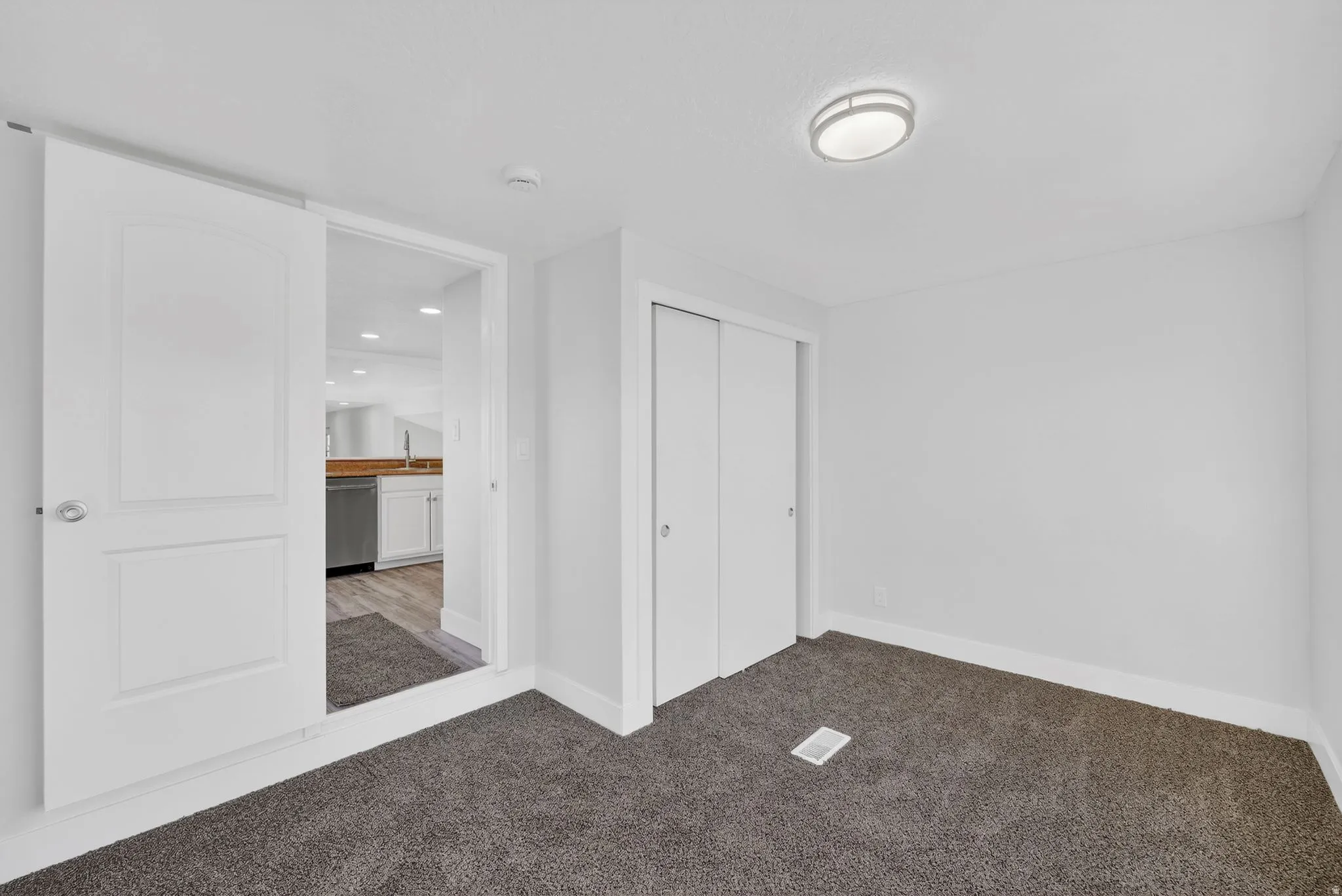 Unfurnished bedroom featuring light colored carpet and a closet