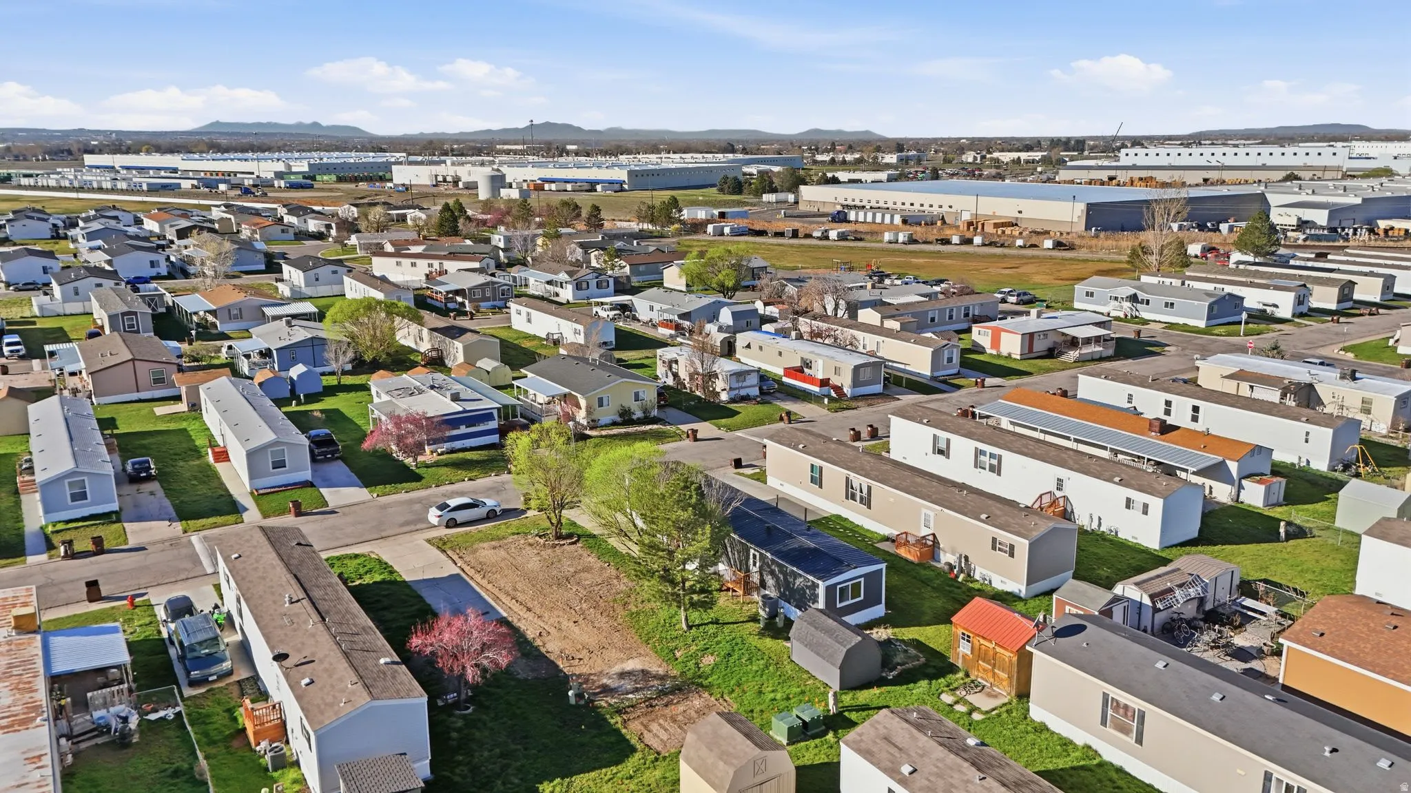 Aerial view of property and surrounding area featuring a mountain backdrop