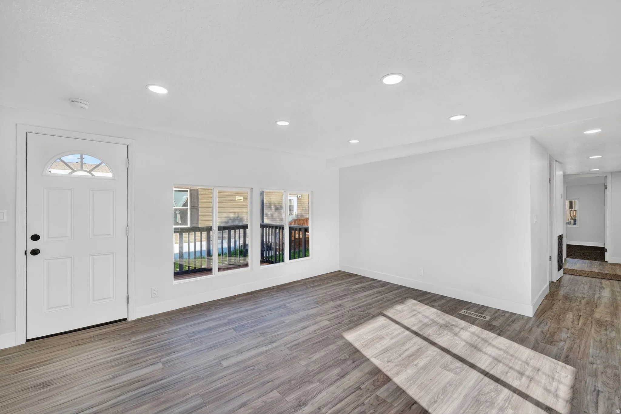 Foyer with dark wood finished floors and recessed lighting