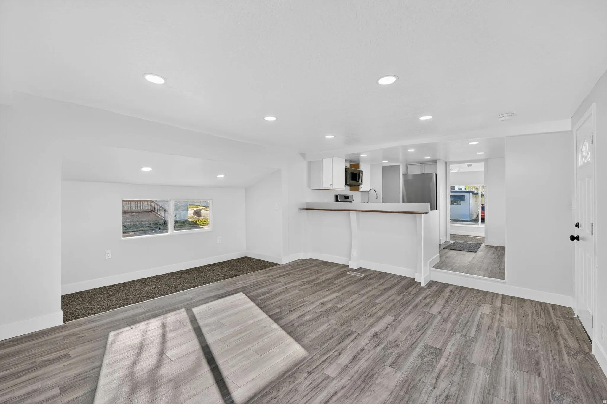 Unfurnished living room with dark wood-type flooring and recessed lighting