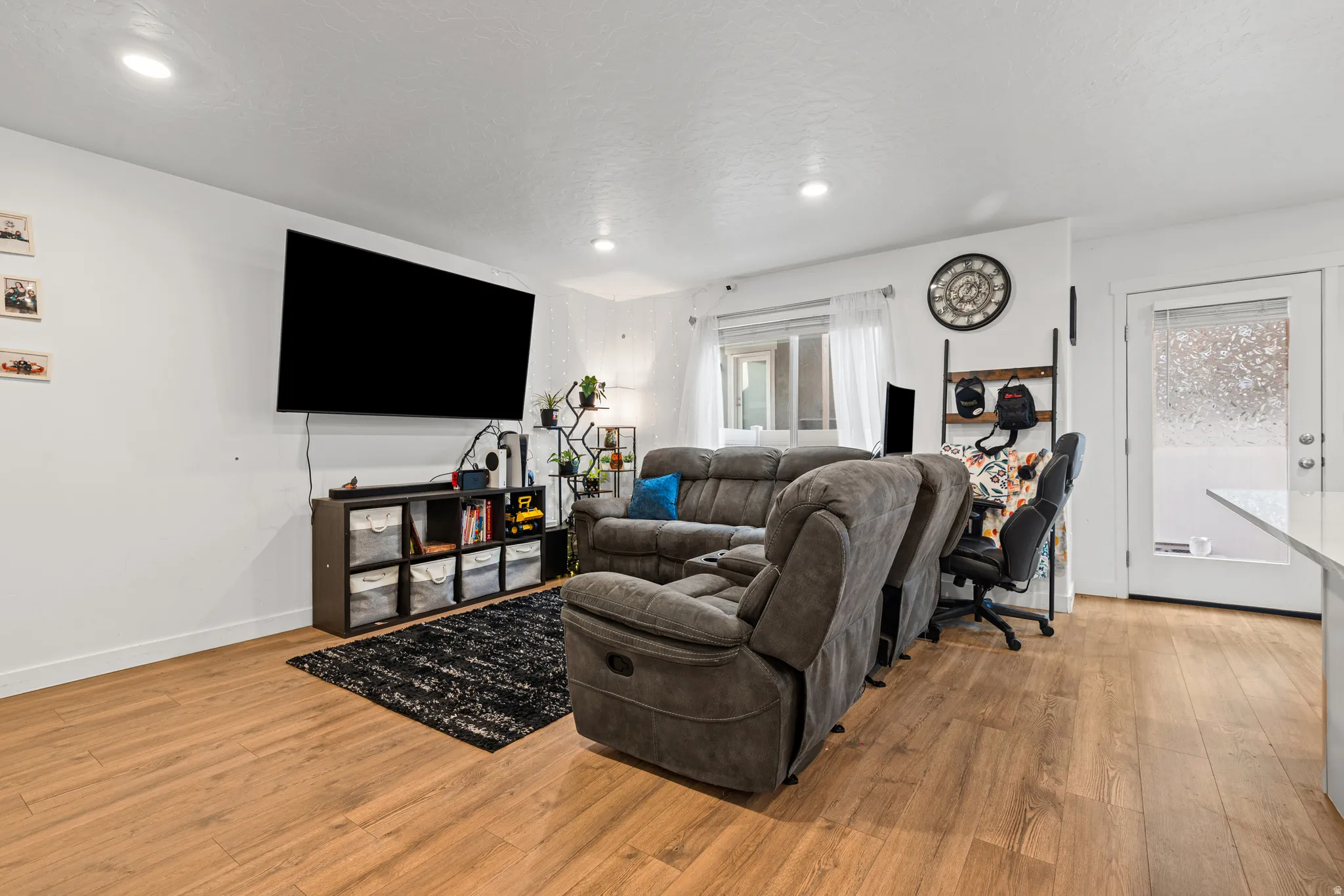 Living room with light wood-type flooring and recessed lighting