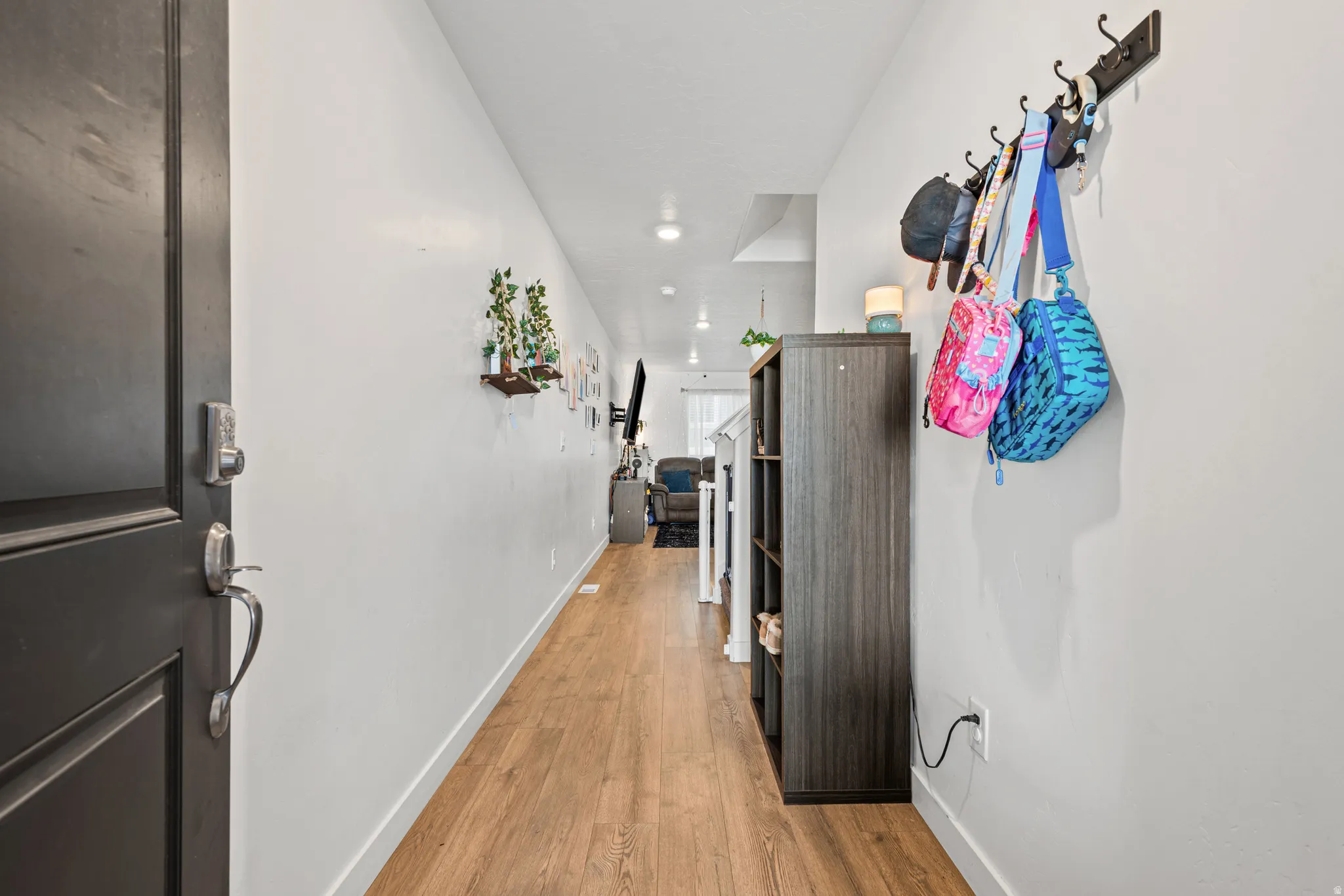 Hallway with light wood-style flooring and recessed lighting