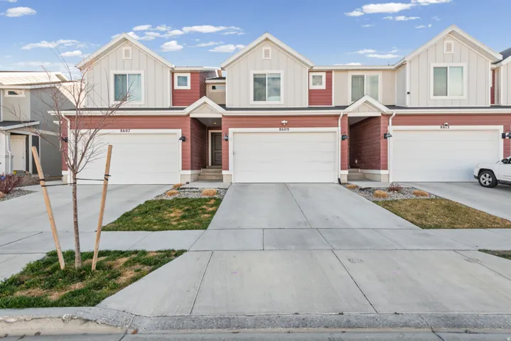 View of front of home featuring board and batten siding, a garage, and concrete driveway