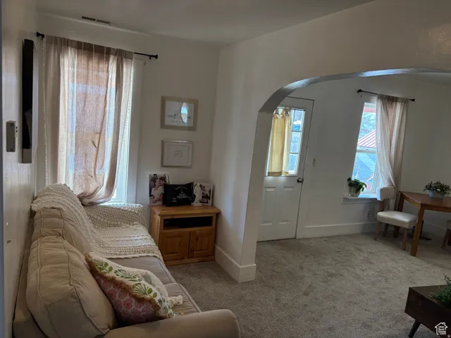 Sitting room with arched walkways and light colored carpet