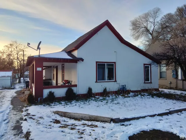 Snow covered property featuring stucco siding