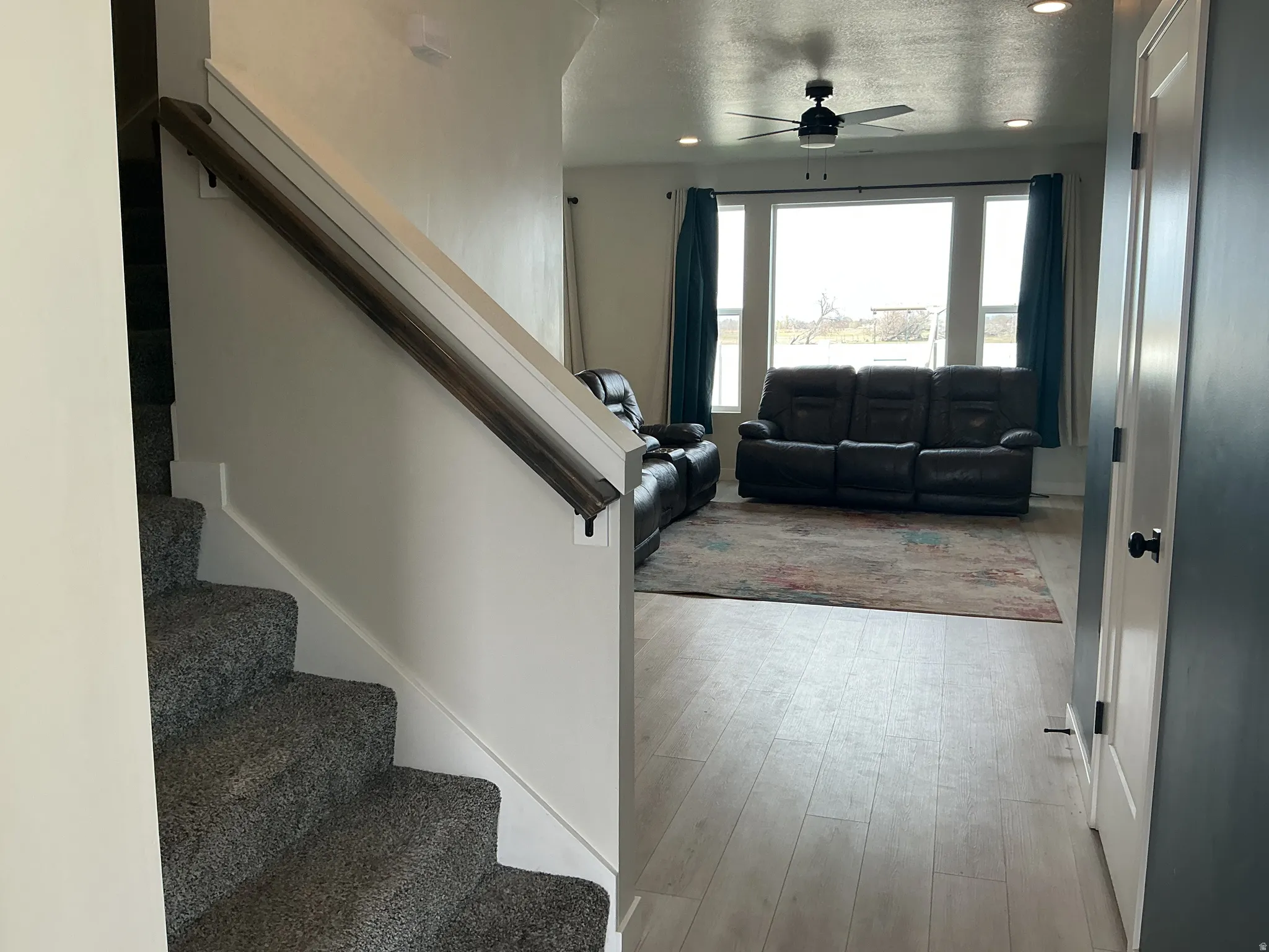Entryway with a ceiling fan, recessed lighting, light wood-type flooring, and a textured ceiling