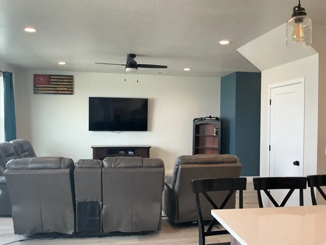 Living area with recessed lighting, light wood-type flooring, a ceiling fan, and a textured ceiling