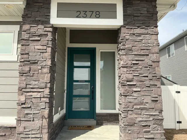 View of exterior entry featuring stone siding