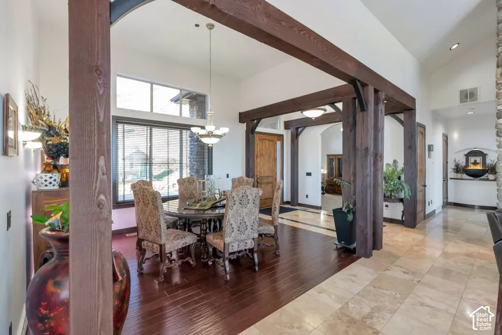 Dining room featuring arched walkways, wood finished floors, lofted ceiling, and hanging lights