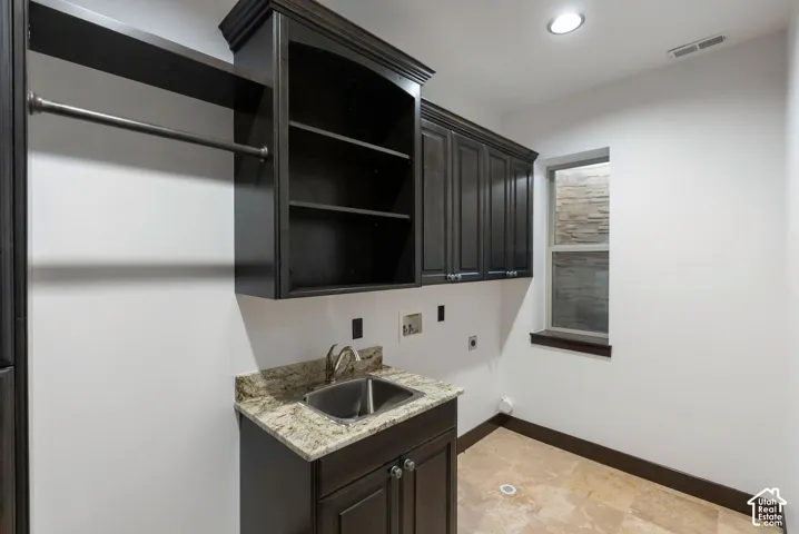Laundry room with washer hookup, electric dryer hookup, and cabinet space