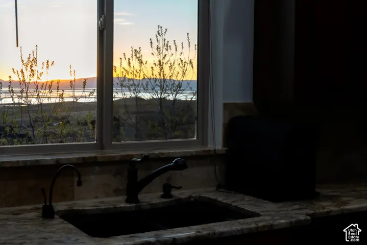 Kitchen view of light stone counters and mountains