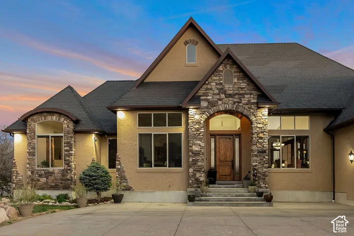 View of front of property with stone siding, stucco siding, and entry steps