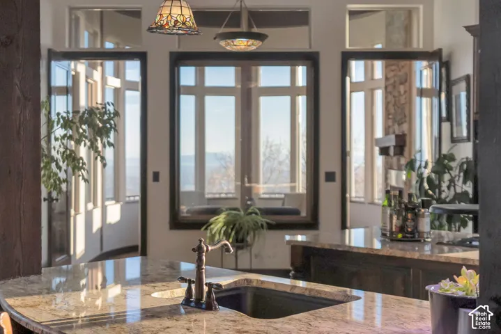 Kitchen featuring light stone counters and a sink