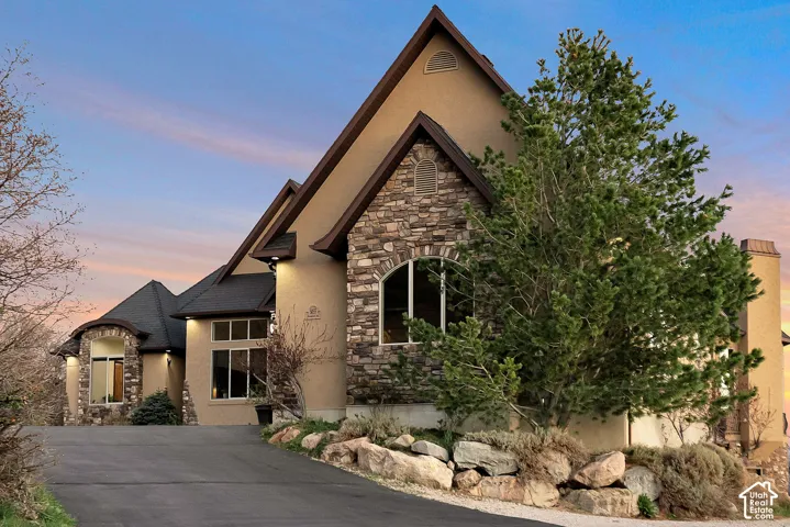 View of front facade featuring stone siding and stucco siding
