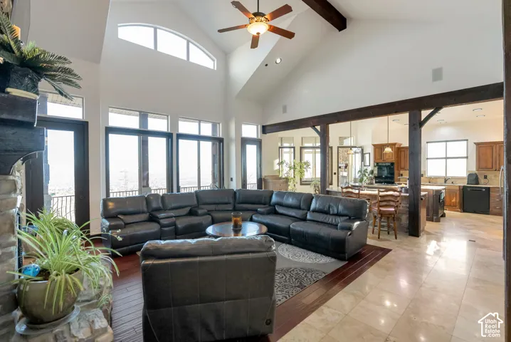 Living room featuring ceiling fan, recessed lighting, and a high ceiling