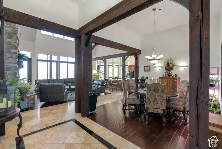 Dining room featuring healthy amount of natural light, inlaid floor details, hanging lights, and a wood stove