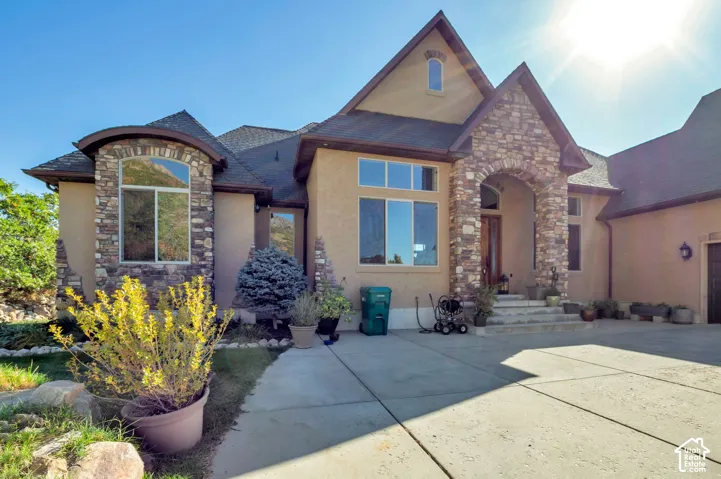 Stone facade accenting a stucco exterior with a prominent arched entry
